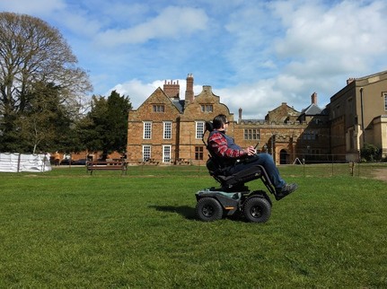 Nick Wilson in the Quantum Outback all-terrain powerchair on the lawns in front of Delapre Abbey