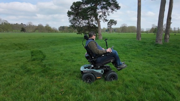 Nick Wilson riding the Quantum Outback all-terrain powerchair across open parkland
